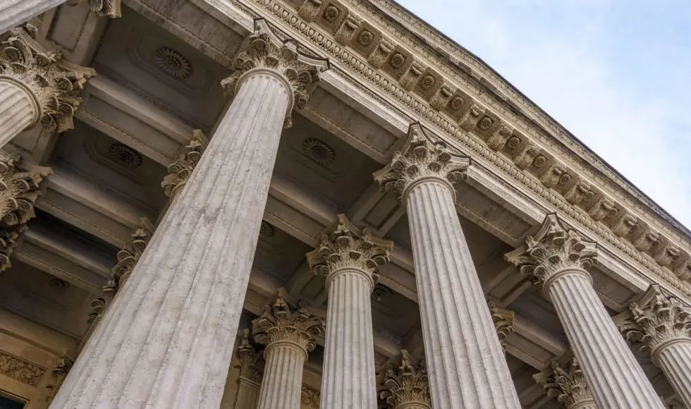 Vintage Old Justice Courthouse Column. Stone column ancient classic architecture detail. Abstract view of neoclassical fluted columns bases and steps of Court building
