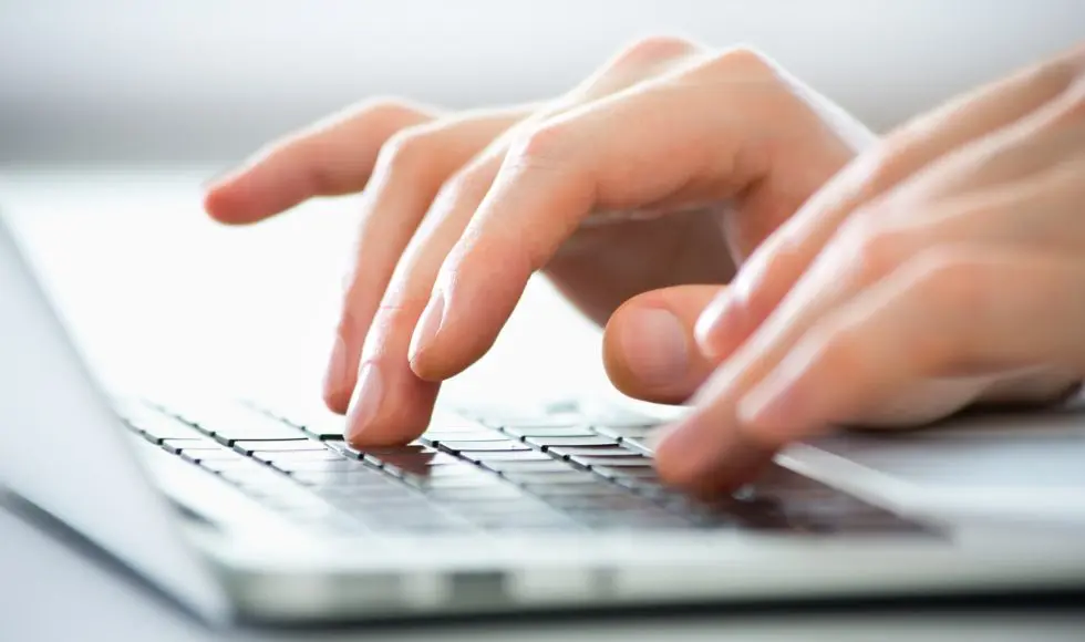 Close-up of hands of business man typing on a laptop.